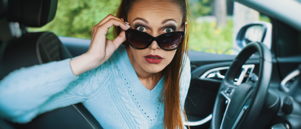 Subpage header, woman with lowered sunglasses in a car