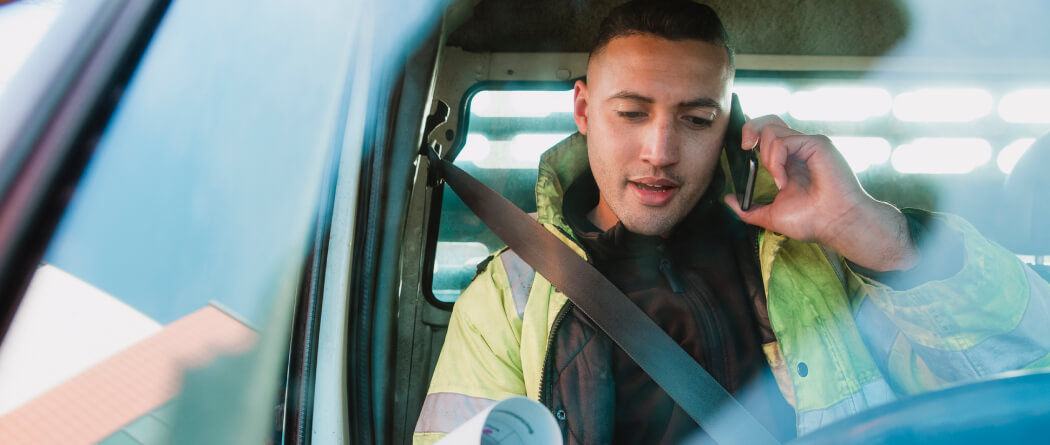 Young man in a high-vis jacket sitting in a car